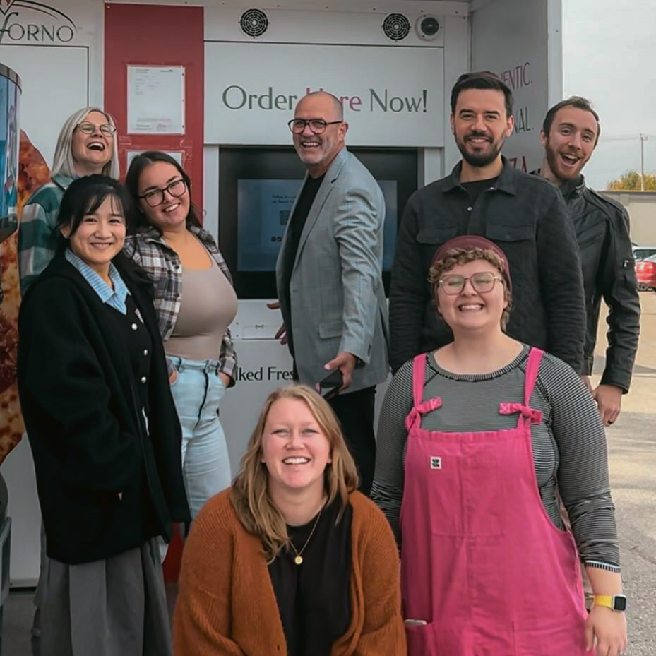 Chez Koop design team excited at outdoor event in Steinbach Manitoba, showcasing vibrant branding and creativity.